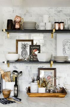 the shelves in this kitchen are filled with plates, bowls and utensils on them