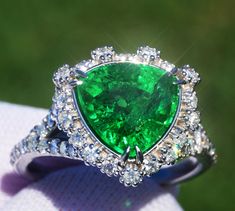 A Breathtakingly Striking  HANDMADE 14k White Gold Ring with Beautiful Modified Triangular Cut Tsavorite in Green color! The GEM is 4.30 CT and measures 9.70x9.94x6.17 mm! This Stone will take your breath away, especially on the sunlight! You will want to look at this stone endlessly. The mounting is a masterpiece! HANDMADE 14K White Gold Mounting (tested), that was is custom made to Accommodate this Beauty of a Gem in Prongs setting! Super FINE Workmanship on the Diamond prong  setting with 42 pcs Brilliant Full Cut Diamonds in GH color, SI1 clarity, totaling to approx 0.7 ct! Fabulous Braided Band and Diamond Gallery! The Entire Top's outline is 14.5x14.7 mm- HUGE. The Ring weights 5.8 g, nice and SOLID. Sits 8.1 mm off the top of the finger. Finger size 7.5 (Free Re-sizing with purchase Luxury Tsavorite Rings With Round Cut, Trillion Cut Emerald Ring For Formal Occasions, Gia Certified Trillion Cut Jewelry For Formal Occasions, Gia Certified Trillion Cut Emerald Wedding Ring, Formal Heart Cut Emerald Ring With Gemstone, Exquisite Tsavorite Jewelry For Anniversary, Formal Jewelry With Trillion Cut Halo Setting, Formal Trillion Cut Jewelry With Halo Setting, Gia Certified Trillion Cut Fine Jewelry