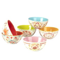 five colorful bowls with spoons in them on a white background, one is empty