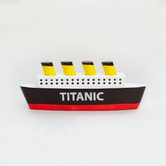 a white and black boat with yellow markers on it's side is sitting on a white surface