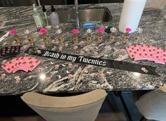 a table topped with lots of pink and black candy bar wrappers on top of a granite counter