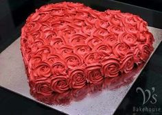 a heart shaped cake with red frosting roses