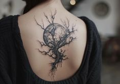 a woman with a tree tattoo on her back shoulder and the moon in the background