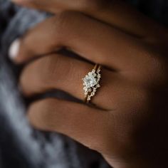 a woman's hand wearing a gold ring with diamonds on the middle and side