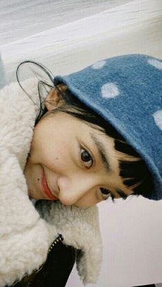 a young woman wearing a blue and white polka dot hat