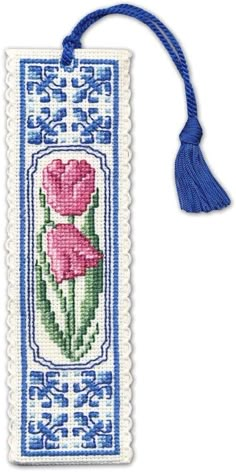 a blue and white bookmark with pink flowers on the front, and a tassel hanging from it