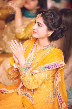 a woman in yellow dress sitting down and clapping