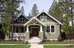 a house that is painted gray and has white trim on the front door, windows, and porch