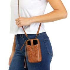 a woman is holding a brown purse on her shoulder