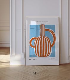 an orange and white striped vase sitting on top of a wooden floor next to a wall