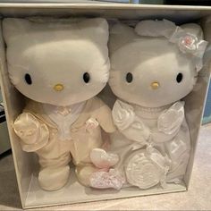 two white teddy bears in a box with flowers on the bottom and one is wearing a wedding dress