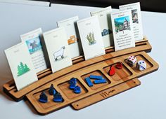 a wooden board with cards and dices on it sitting on top of a table