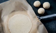 some doughnuts are sitting on a piece of parchment paper next to a pair of tongs