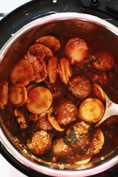 a pot filled with meatballs and sauce on top of a stove