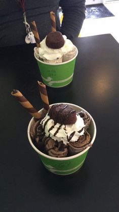 two green cups filled with ice cream and chocolate cookies