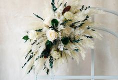 a white flower arrangement sitting on top of a chair