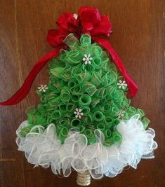 a green christmas tree with red bows on it's head and white tulle skirt