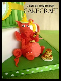 there is a cake made to look like a red dragon with a crown on his head