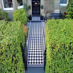 a black and white checkered walkway leading to a door