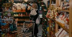 a woman standing in a store with a shopping cart