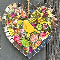 a heart shaped stained glass decoration hanging on a wooden door with flowers and leaves in the center