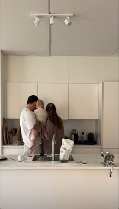 a man and woman standing in front of a kitchen sink