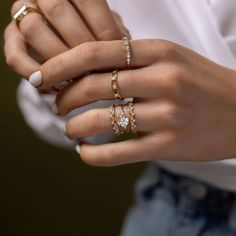 a woman's hand with three different rings on it