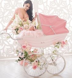 a woman sitting in a pink carriage with flowers