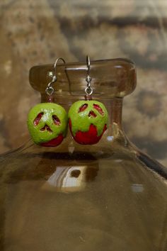 With a tempting shine, the poisoned apple waits, holding sweet secrets that fate creates. Indulge in this Halloween season with these adorable poisoned apple earrings! Crafted from high-quality polymer clay and stainless steel hardware, each piece is hand-painted with intricate details. Measuring approximately 1.5 inches, these lightweight earrings are perfect for adding a mystical touch to your everyday wear. Whether you're a diehard halloween-lover or just someone who appreciates unique accessories, these earrings will have even the graveyard buzzing with excitement. They make a spine-tingling gift for your skelefriends or a thrilling treat for yourself! This collection is inspired by the magic of Halloween--bringing together the eerie charm of the season with handcrafted artistry. I ado Quirky Handmade Halloween Jewelry, Fantasy Halloween Dangle Earrings, Whimsical Handmade Halloween Earrings, Quirky Halloween Earrings, Poisoned Apple, Halloween Novelty Drop Earrings, Apple Earrings, Earrings Cute, Lightweight Earrings