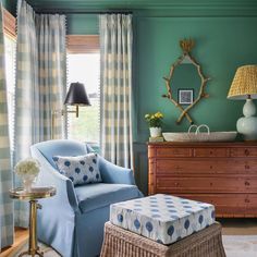 a living room with green walls and blue furniture