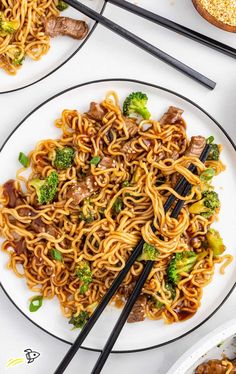 two plates with noodles, broccoli and meat on them next to chopsticks