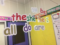 bulletin board hanging from the ceiling with words all do are spelled in different colors and shapes