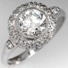 an antique style diamond ring is shown in this close up photo, with the center stone surrounded by smaller round diamonds