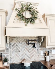 a kitchen stove top with a wreath on it's mantle above the rangetop