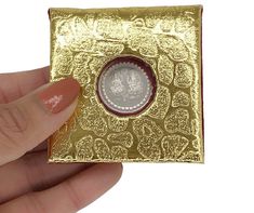 a person holding a gold and silver coin in their left hand, with the image of an elephant on it's back