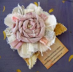 a pink and white flower sitting on top of a purple table cloth covered with confetti