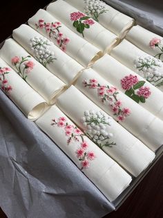 a box filled with white napkins covered in pink and white flowers