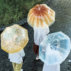 three people with umbrellas walking down the street