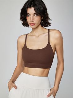 Why We Love It: Achieve peak performance and effortless style with the Gemma Cami Sports Bra. This versatile piece combines a chic design with essential support, perfect for any workout routine. Fit and Features: Light-to-medium support for a wide range of activities. Built-in bra with removable padding for customizable comfort. Scoop neckline adds a touch of elegance. Adjustable straps ensure a perfect fit. Breathable and moisture-wicking fabric keeps you cool and dry. Seamless construction pro Brown Fitted Sports Bra For Gym, Fitted Brown Sports Bra For Gym, Versatile Brown Yoga Activewear, Fitted Brown Sports Bra, Brown Athleisure Activewear For Training, Brown Seamless Activewear, Sporty Brown Activewear For Training, Brown Athleisure Sports Bra For Workout, Brown Seamless Athleisure Activewear