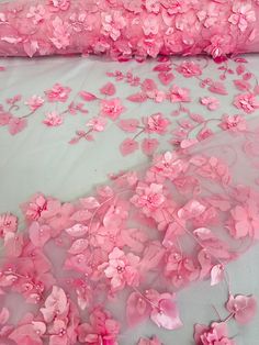 pink flowers are scattered all over the bed