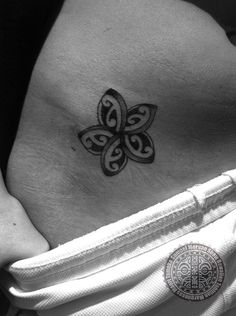 a black and white photo of a woman's stomach with a butterfly tattoo on it