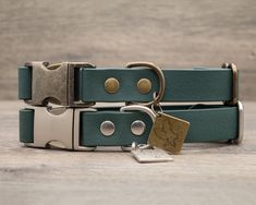 two green leather dog collars with brass hardware on each side and a key to the other side