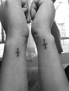 two hands holding up their wrist tattoos with the numbers 1 and 2 tattooed on them