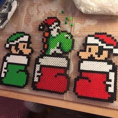 four pixelated christmas ornaments sitting on top of a wooden table next to each other