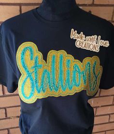 This listing is for a STALLIONS unisex shirt. This embroidered shirt comes in colors/fabric prints of your choice.  THIS LISTING IS ONLY FOR THE MASCOT SHIRT PICTURED AND LISTED ABOVE  OTHER MASCOTS ARE AVAILABLE PLEASE MESSAGE US OR BROWSE OUR SHOP. IF THIS SHIRT IS ORDERED AND YOU PUT ANOTHER MASCOT NAME IT WILL BE CANCELLED. Feel free to request color changes. If you have no special requests, your design will resemble the first picture in the listing as closely as possible. Some fabrics in the applique design may differ slightly depending on availability of fabric. We use a mix of HTV glitter or glitter fabric and sequins on our designs.  We use unisex Gildan brand sweatshirts, Gildan softstyle t-shirt and Gildan long sleeve shirt for most orders we also use other brands when needed.  W Black Custom Embroidered Tops For College, Black Tops With Custom Embroidery For College, Black Custom Embroidery Tops For College, Cotton Tops With Embroidered Graphics For Fans, Fan Apparel Cotton T-shirt With Embroidered Graphics, Cotton Tops With Embroidered Graphics For Team Spirit, College School Spirit T-shirt With Custom Embroidery, College T-shirt With Custom Embroidery For School Spirit, Blue T-shirt With Embroidered Graphics For School Spirit