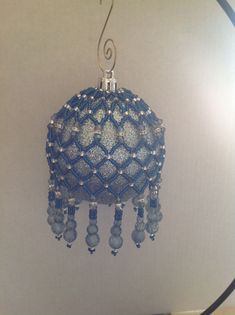 a blue beaded lamp hanging from a ceiling