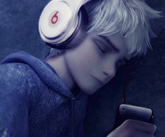 a young man with headphones is looking at his cell phone