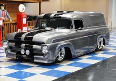 an old truck is parked on a checkered floor