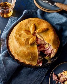 there is a pie that has been cut in half on the table with other plates