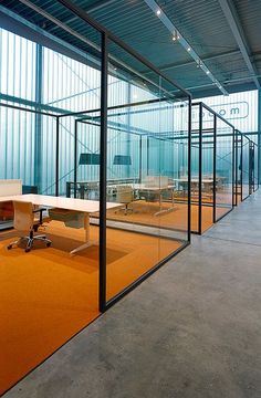 an empty office with glass walls and desks